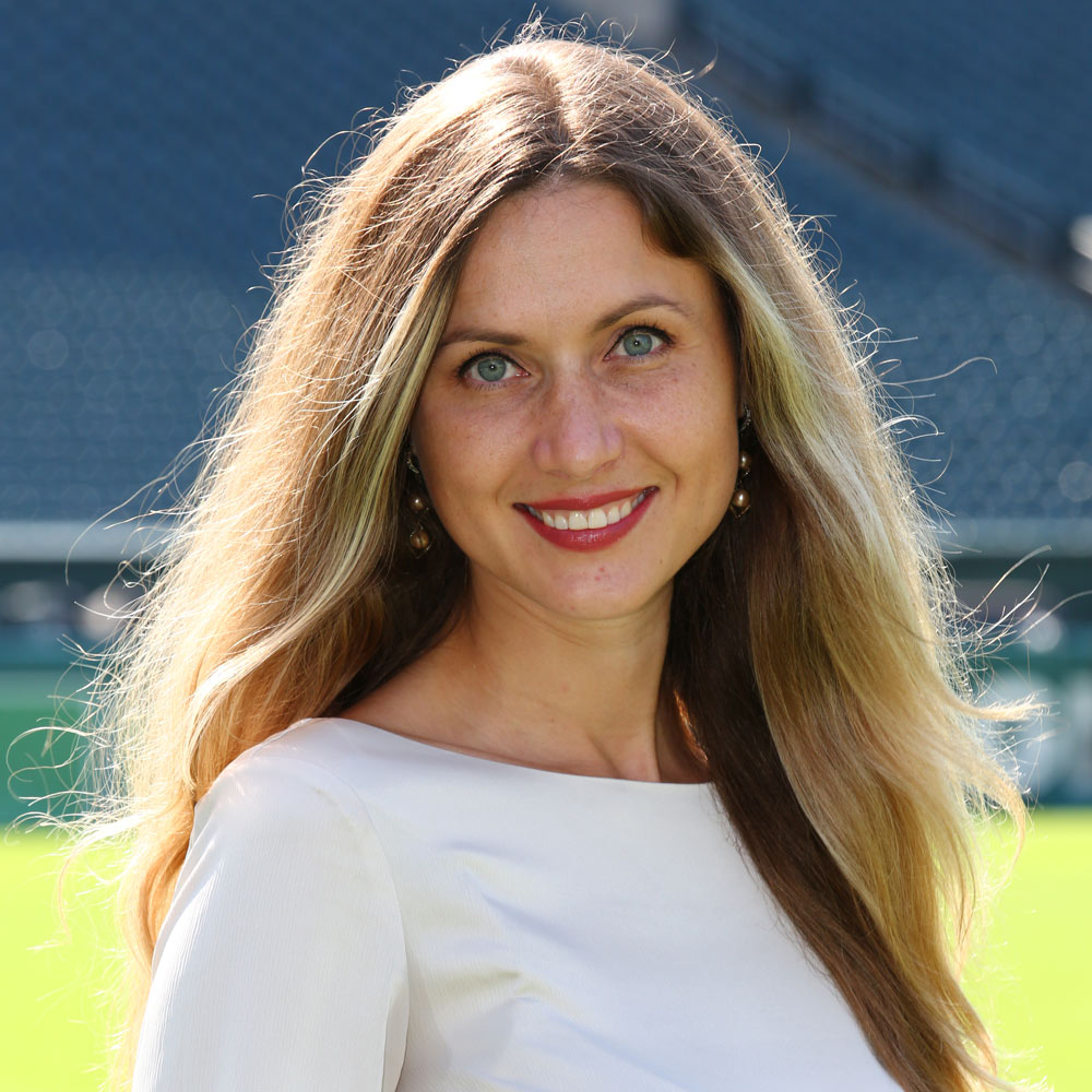 Dr Olena Akbulut smiling and standing in a football field